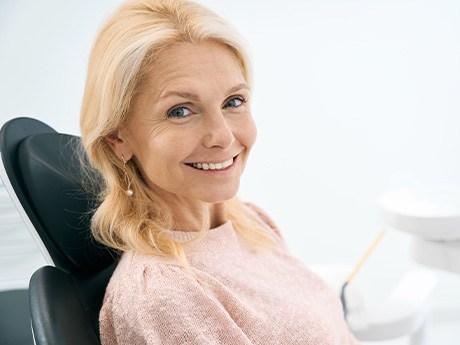 Middle-aged female smiling at the cost of dental crowns in Marysville