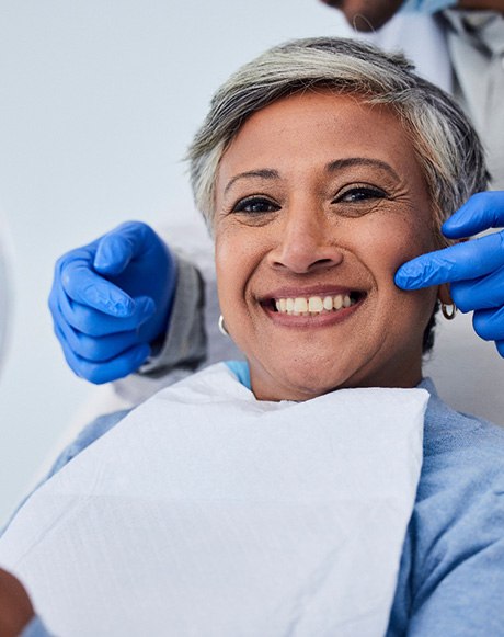 Woman smiling while holding handheld mirror