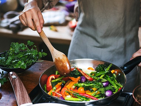 Patient preparing vegetables in kitchen at home