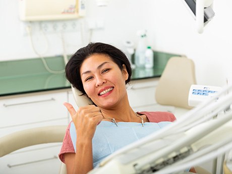 Woman giving thumbs up during dental checkup