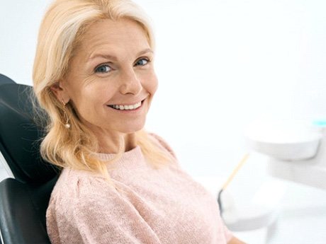 a patient smiling after receiving her dental implants